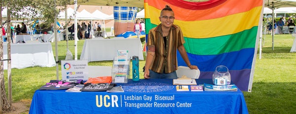 LGBTRC student working on information booth with Pride flag.