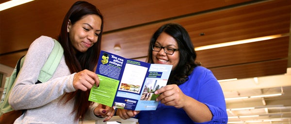 Students reading Financial Aid brochure.