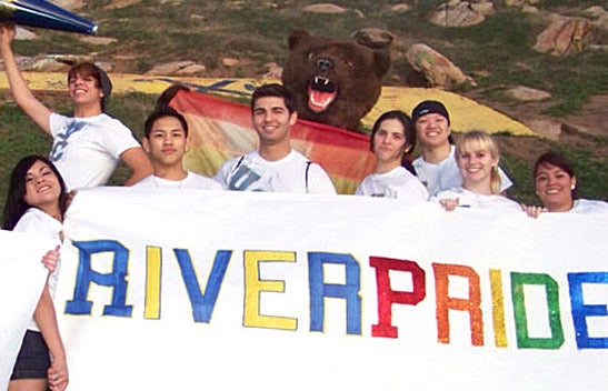 LGBTRC students holding RiverPride banner with Scotty.